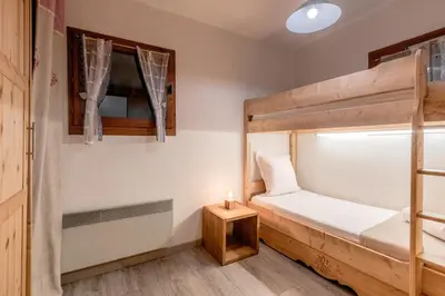 a bedroom with a bunk bed and a candle on a table at Jardin du Mont Blanc in Chamonix-Mont-Blanc