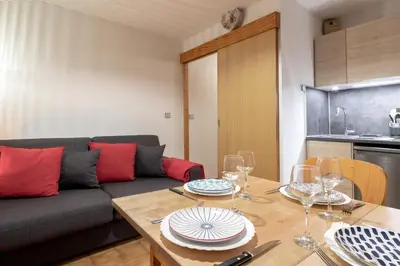 a living room with a couch and a table with wine glasses at Jardin du Mont Blanc in Chamonix-Mont-Blanc