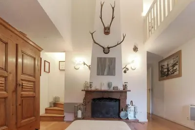 a living room with a fireplace with antlers on the wall at Le Bedux - Privée - Calme - Terrasse - Vues in Chamonix-Mont-Blanc