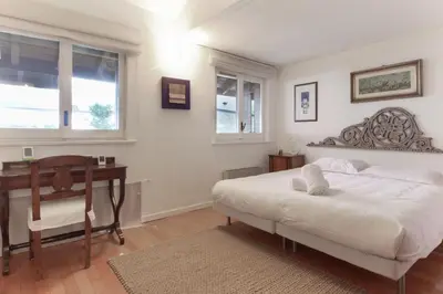 a bedroom with a bed and a desk and windows at Le Bedux - Privée - Calme - Terrasse - Vues in Chamonix-Mont-Blanc