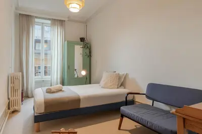 a bedroom with a bed and a couch and a window at Le Metropole - Centre-ville - Spacieux in Chamonix-Mont-Blanc