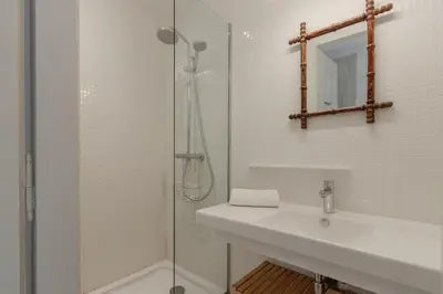 a white bathroom with a sink and a shower at Le Metropole - Centre-ville - Spacieux in Chamonix-Mont-Blanc