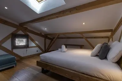 a bedroom with a large white bed in a attic at Chalet Des Grands Vanays in Les Houches