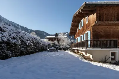 a snow covered yard in front of a building at Chalet Des Grands Vanays in Les Houches