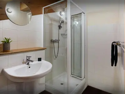 a white bathroom with a sink and a shower at Chalet Les Pellys - OVO Network in Samoëns