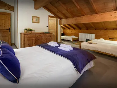 a large bedroom with two beds and wooden ceilings at Chalet Les Pellys - OVO Network in Samoëns