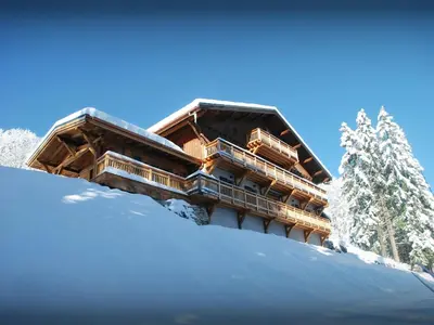 a building on a snow covered hill with snow at Chalet Les Pellys - OVO Network in Samoëns