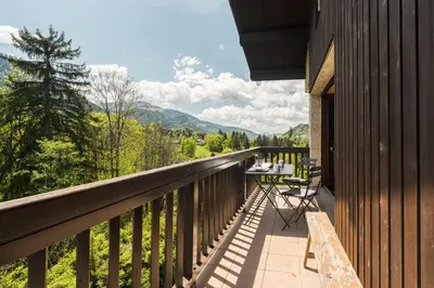 a balcony of a house with a table and chairs at Appartement Cornec - Your stay in Megève in Megève