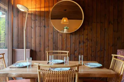 a wooden table with chairs and a mirror on a wall at Appartement Cornec - Your stay in Megève in Megève