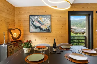 a dining room with a table with chairs and a window at La Yaute Chamonix-Les Houches in Les Houches