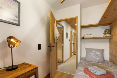 a room with a bed and a lamp and a hallway at La Yaute Chamonix-Les Houches in Les Houches