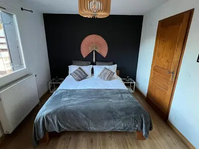 a bedroom with a large bed with a black wall at Chamonix Charmant duplex 4 personnes et un enfant in Chamonix-Mont-Blanc