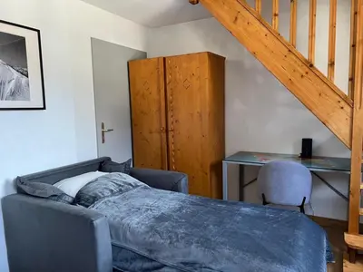 a bedroom with a bed and a desk and a ladder at Chamonix Charmant duplex 4 personnes et un enfant in Chamonix-Mont-Blanc