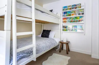 a bedroom with two bunk beds and a table at Spacieux 6pax 3ch Vue MtBlanc Central Parking in Chamonix-Mont-Blanc
