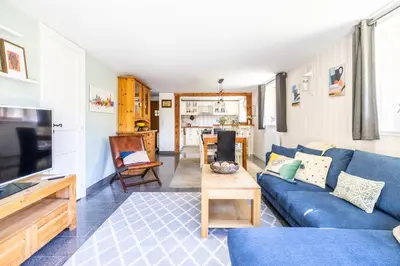 a living room with a blue couch and a table at Spacieux 6pax 3ch Vue MtBlanc Central Parking in Chamonix-Mont-Blanc