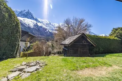 a small building in a yard with a snow covered mountain at Spacieux 6pax 3ch Vue MtBlanc Central Parking in Chamonix-Mont-Blanc