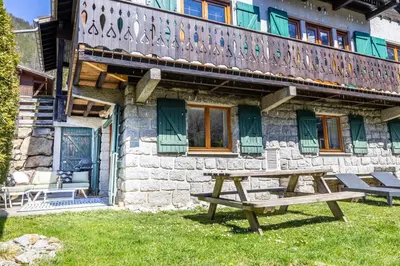 a wooden picnic table in front of a building at Spacieux 6pax 3ch Vue MtBlanc Central Parking in Chamonix-Mont-Blanc
