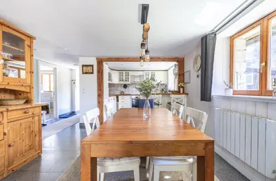 a kitchen and dining room with a wooden table and chairs at Spacieux 6pax 3ch Vue MtBlanc Central Parking in Chamonix-Mont-Blanc