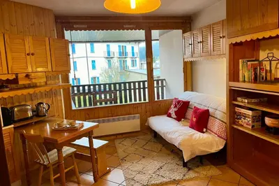 a kitchen with a couch and a table and a window at City center studio near the slopes in Chamonix-Mont-Blanc