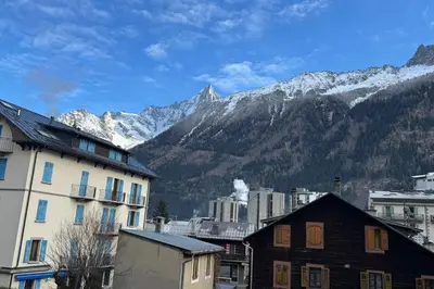 a city with buildings and mountains in the background at City center studio near the slopes in Chamonix-Mont-Blanc
