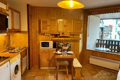 a kitchen with a table and a microwave at City center studio near the slopes in Chamonix-Mont-Blanc