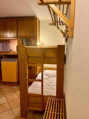 a room with a bunk bed in a kitchen at City center studio near the slopes in Chamonix-Mont-Blanc