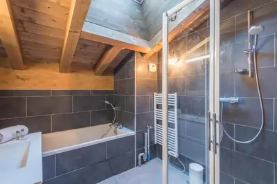 a bathroom with a shower and a sink and a tub at Belvédère du Brévent - Welkeys in Chamonix-Mont-Blanc