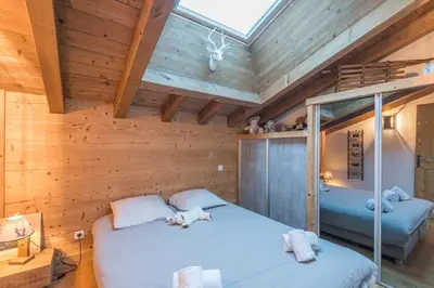 two beds in a room with wooden walls at Belvédère du Brévent - Welkeys in Chamonix-Mont-Blanc