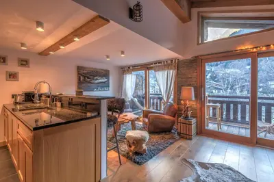 a kitchen with a sink and a living room at Belvédère du Brévent - Welkeys in Chamonix-Mont-Blanc