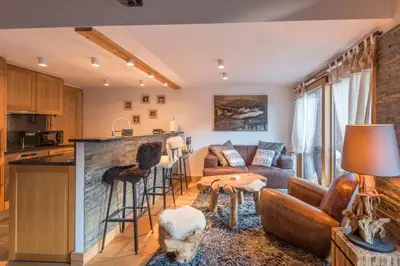 a kitchen and living room with a couch and a table at Belvédère du Brévent - Welkeys in Chamonix-Mont-Blanc