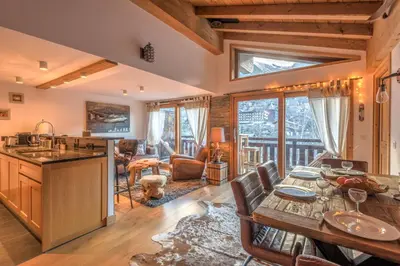 a kitchen and living room with a table and chairs at Belvédère du Brévent - Welkeys in Chamonix-Mont-Blanc