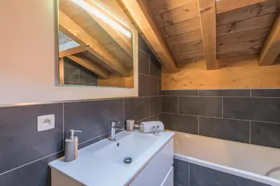 a bathroom with a sink and a mirror and a tub at Belvédère du Brévent - Welkeys in Chamonix-Mont-Blanc