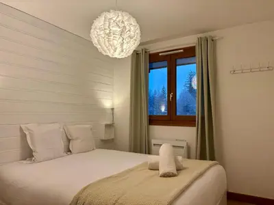 a bedroom with a bed with a chandelier at Capucins 3 in Chamonix-Mont-Blanc