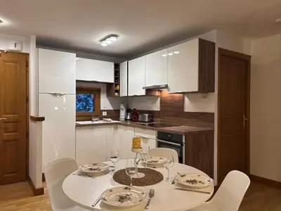 a kitchen with a table and chairs and a kitchen with white cabinets at Capucins 3 in Chamonix-Mont-Blanc