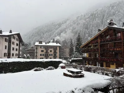 a snow covered city with buildings and a bench at Capucins 3 in Chamonix-Mont-Blanc