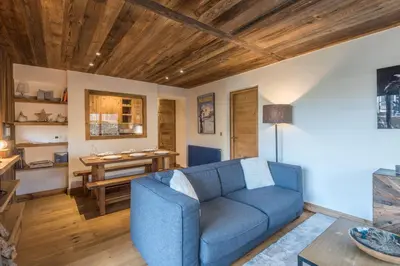 a living room with a blue couch and a table at Duplex Megèvan - Welkeys in Megève