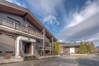 a building with a parking lot in front of it at Duplex Megèvan - Welkeys in Megève