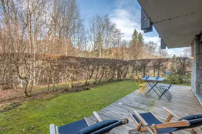 a patio with chairs and a table on a deck at Duplex Megèvan - Welkeys in Megève