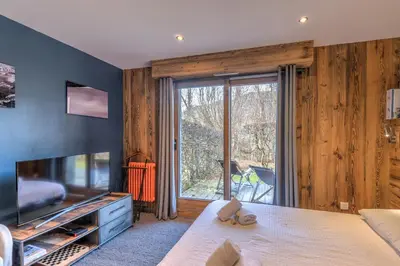 a living room with a large sliding glass door at Duplex Megèvan - Welkeys in Megève