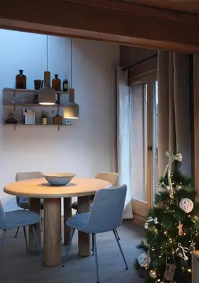 a dining room with a table and a christmas tree at Appartement avec vue sur les Dômes du Miage in Les Contamines-Montjoie