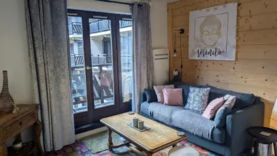 a living room with a blue couch and a table at Central Mont Blanc View Apartment, balcony, free parking in Chamonix-Mont-Blanc