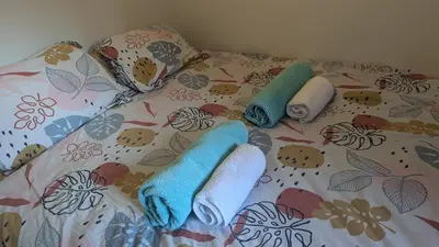 a bed with two towels and pillows on it at Central Mont Blanc View Apartment, balcony, free parking in Chamonix-Mont-Blanc