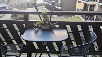 a blue table with a plant on a balcony at Central Mont Blanc View Apartment, balcony, free parking in Chamonix-Mont-Blanc