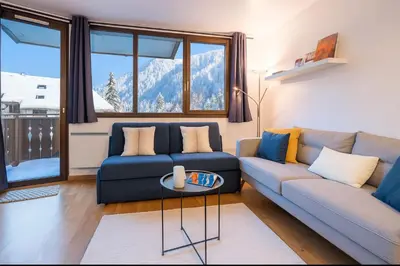 a living room with a blue couch and a table at Escape in Chamonix breathtaking view Mont-Blanc in Chamonix-Mont-Blanc