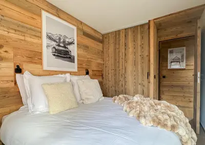 a bed with a teddy bear sitting on top of it at Stella Megeve Palais garage in Megève