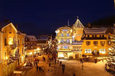 a group of people walking around a town at night at Stella Megeve Palais garage in Megève