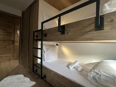 a bedroom with a bunk bed with white sheets at Stella Megeve Palais garage in Megève