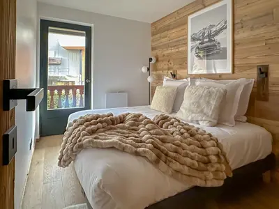 a bedroom with a large bed with a blanket on it at Stella Megeve Palais garage in Megève