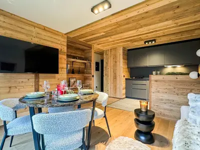 a dining room with a table and chairs and a kitchen at Stella Megeve Palais garage in Megève