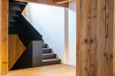 a black staircase in a room with a wooden wall at Chalet de 8 chambres MEGEVE - 16 personnes in Megève